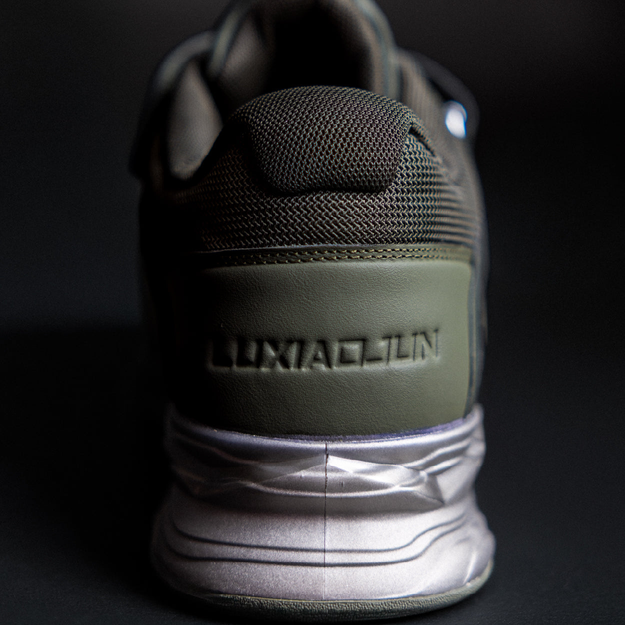 Close-up of a black and green sneaker with 'Luxiaojun' branding on a dark background
