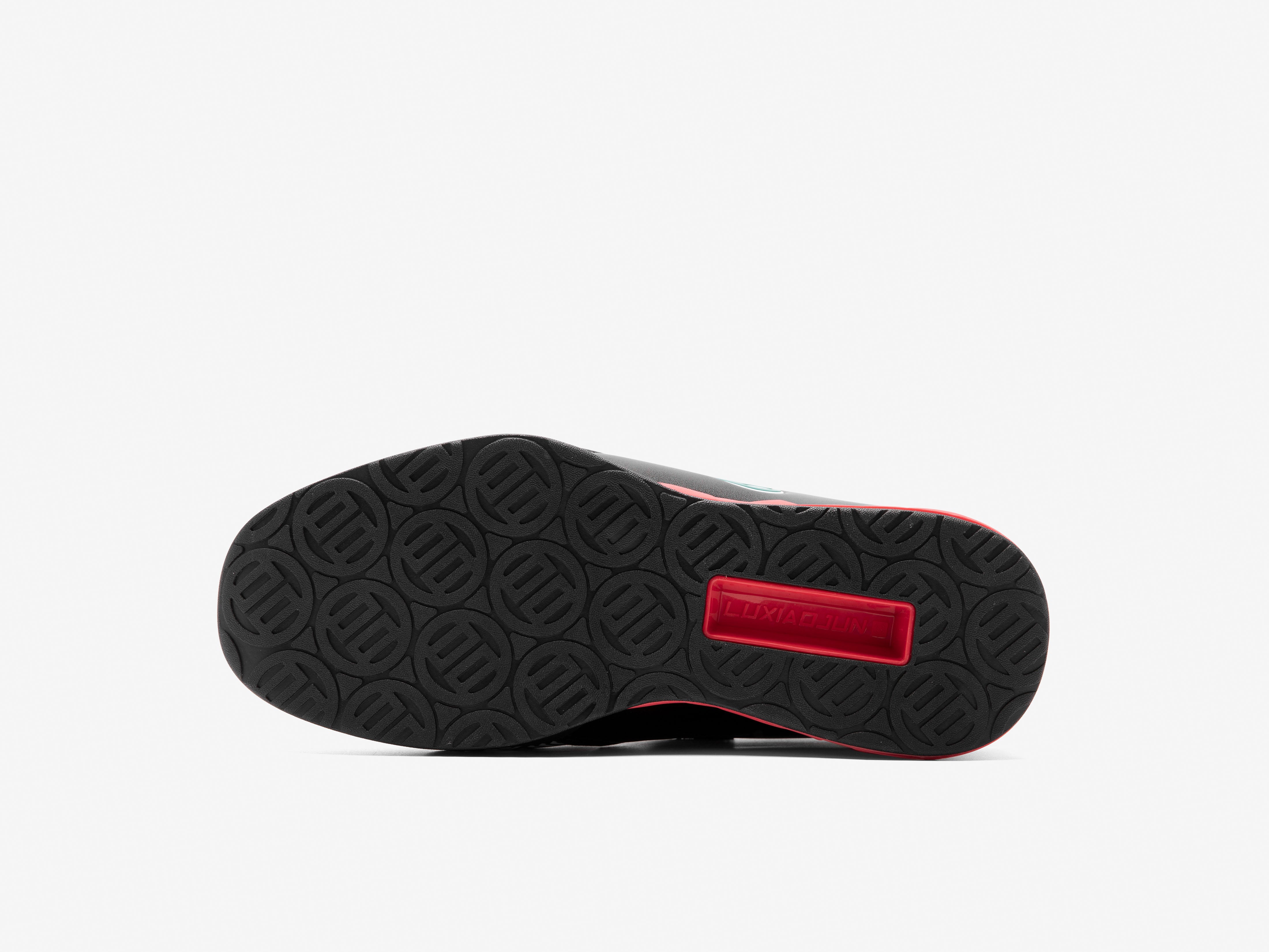 Karlos Edition black shoe sole with red label on a white background