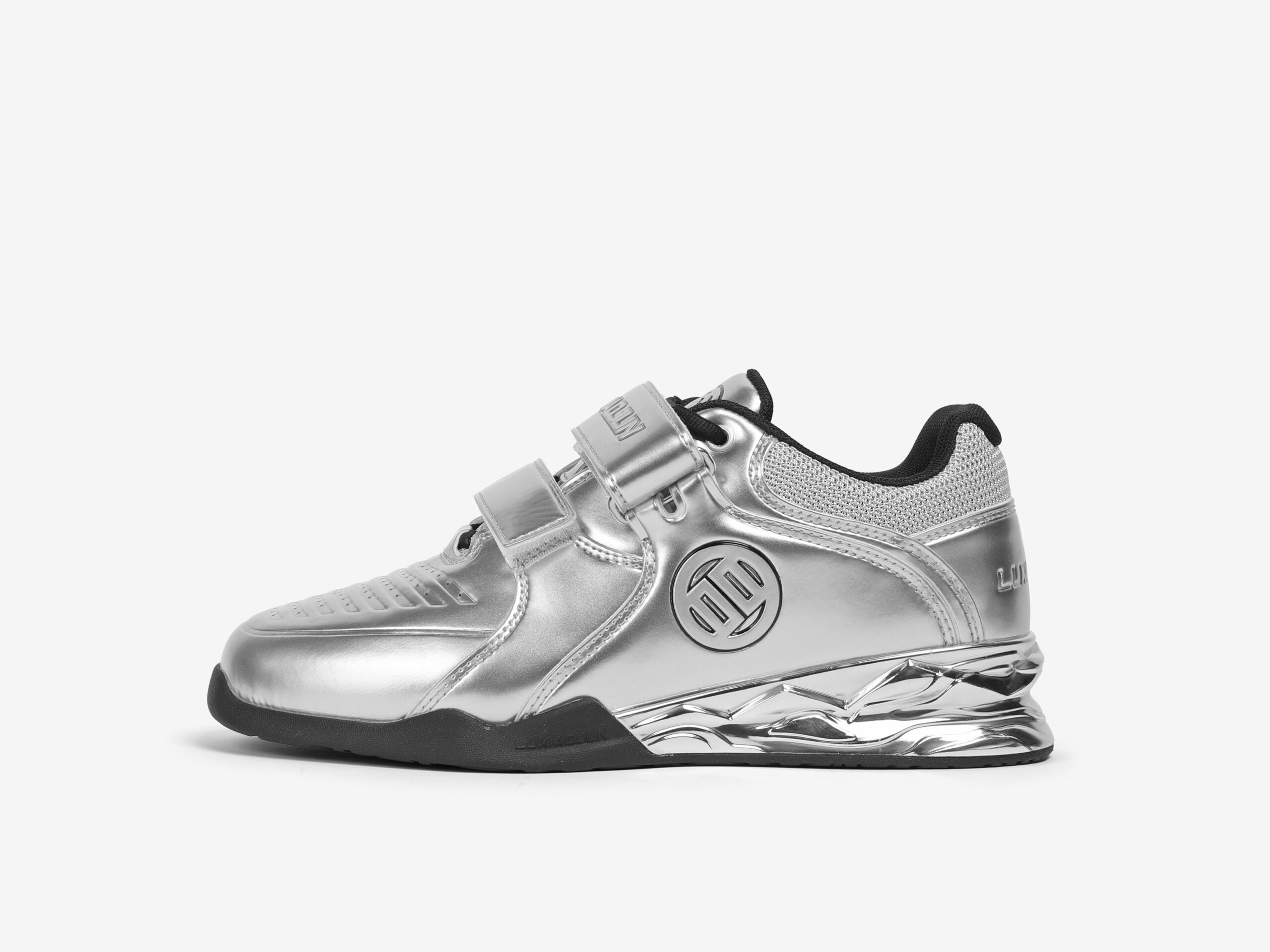A silver weightlifting shoe designed for stability and support during weight training, featuring a distinctive brand logo on the side.