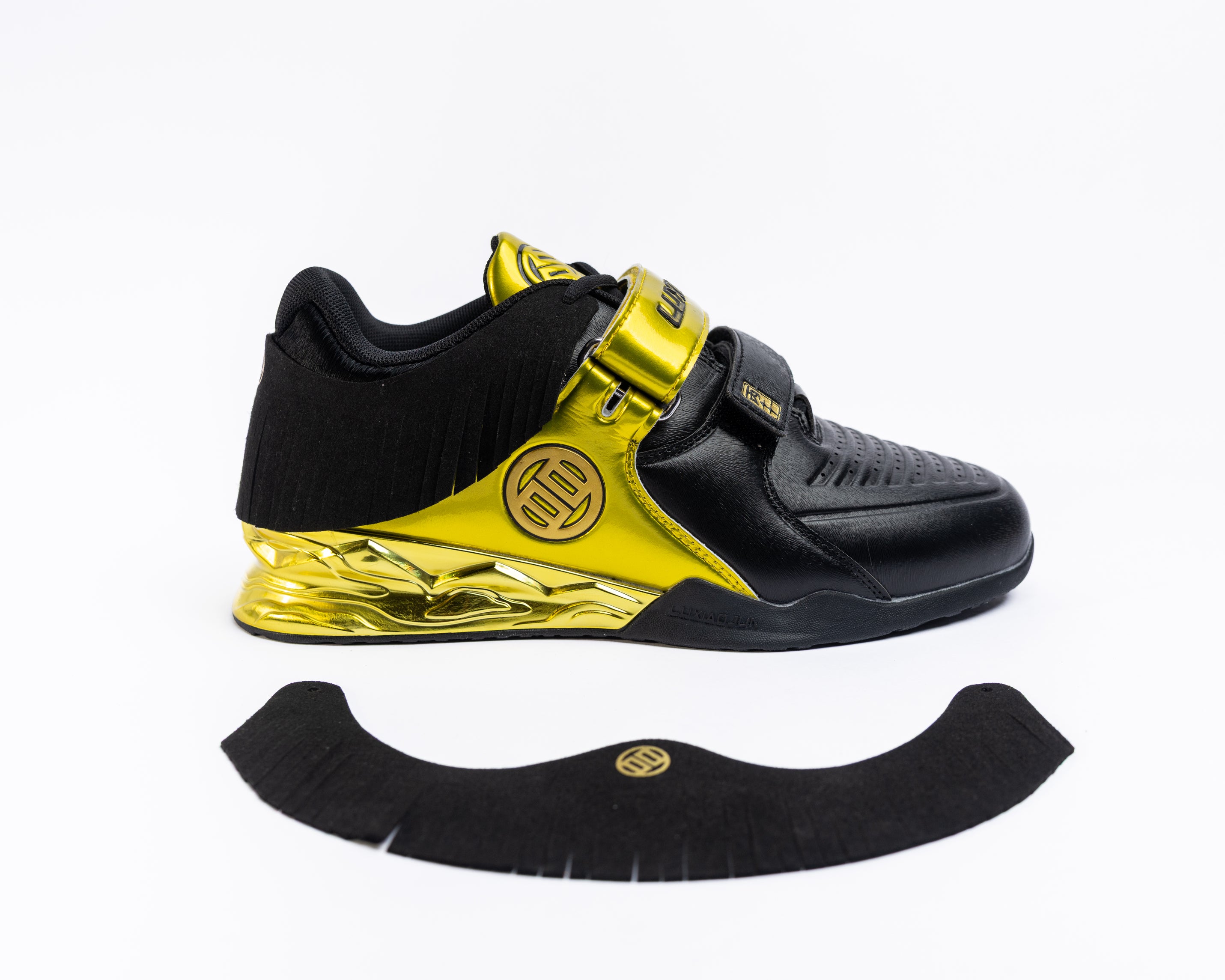 Black and yellow gold athletic shoe with a black sole on a white background