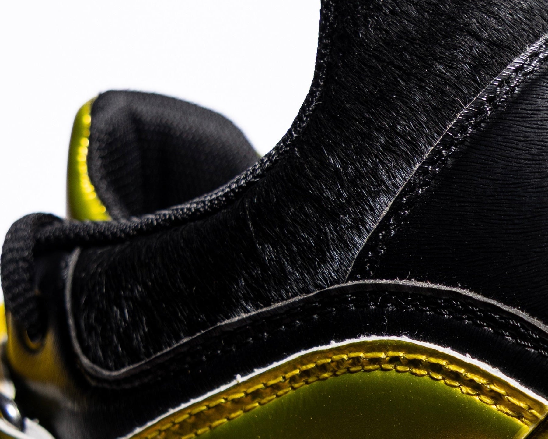 Close-up of a black and yellow gold lifting shoe with a focus on the sole and side.