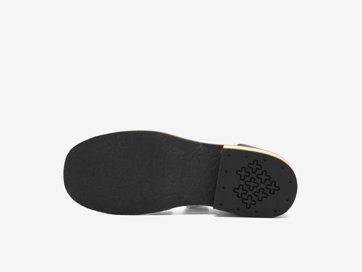 Black outsole of the white Heritage Lifter with the cross pattern tread under the heel